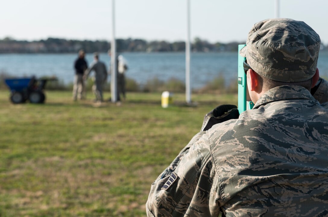 U.S. Air Force Staff Sgt. Seth Johnson, a structural craftsman assigned to the 633rd Civil Engineer Squadron, checks the plum of new flag posts at Memorial Park at Langley Air Force Base, Va., March 24, 2016. Johnson ensured each post was level and not leaning to either side. (U.S. Air Force photo by Airman 1st Class Derek Seifert)