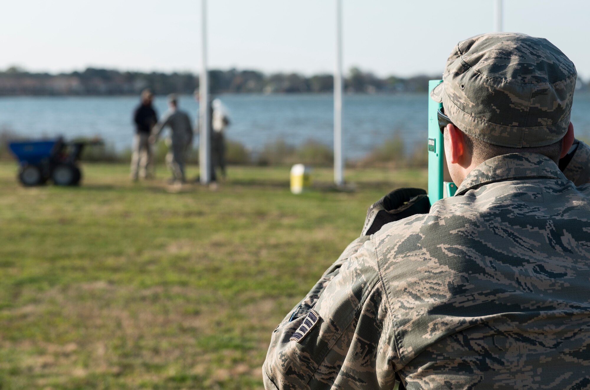 U.S. Air Force Staff Sgt. Seth Johnson, a structural craftsman assigned to the 633rd Civil Engineer Squadron, checks the plum of new flag posts at Memorial Park at Langley Air Force Base, Va., March 24, 2016. Johnson ensured each post was level and not leaning to either side. (U.S. Air Force photo by Airman 1st Class Derek Seifert)