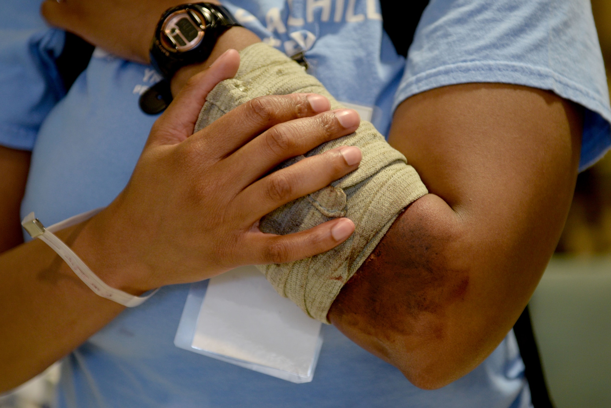 A patient elevates their arm while waiting for medical treatment during a mass casualty exercise at Langley Air Force Base, Va., March 24, 2016. The exercise incorporated each of the different departments of the hospital to ensure all medical staff is prepared in the event of a mass casualty scenario. (U.S. Air Force photo by Airman 1st Class Kaylee Dubois)