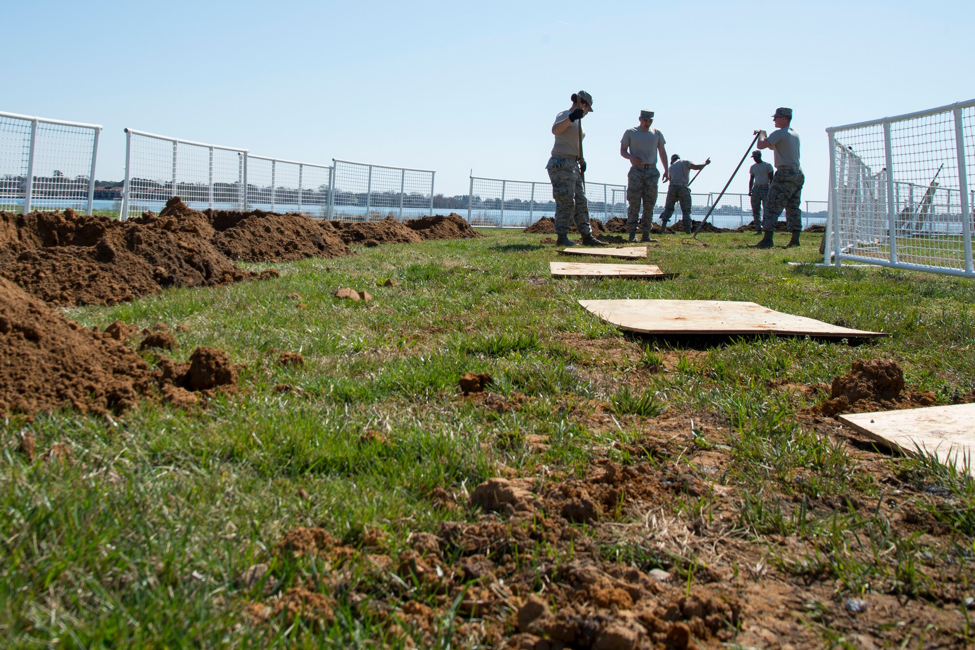 U.S. Air Force Airman 1st Class Cameron Houle, a heavy equipment operator assigned to the 633rd Civil Engineer Squadron, fills an old flag post hole at Langley Air Force Base, Va., March 16, 2016. The heavy equipment operators were creating 58 new flag post holes to install new, sturdier post that can withstand winds up to 200 miles per hour. . (U.S. Air Force photo by Staff Sgt. J.D. Strong II)