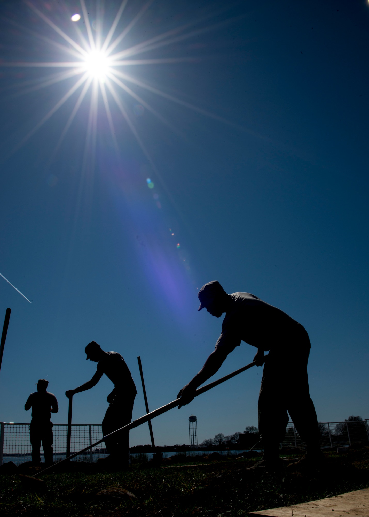 Heavy equipment operators assigned to the 633rd Civil Engineer Squadron, create flag post holes at Langley Air Force Base, Va., March 16, 2016. Post hole diggers and shovels were used to create new post holes for 58 flag poles. (U.S. Air Force photo by Staff Sgt. J.D. Strong II)