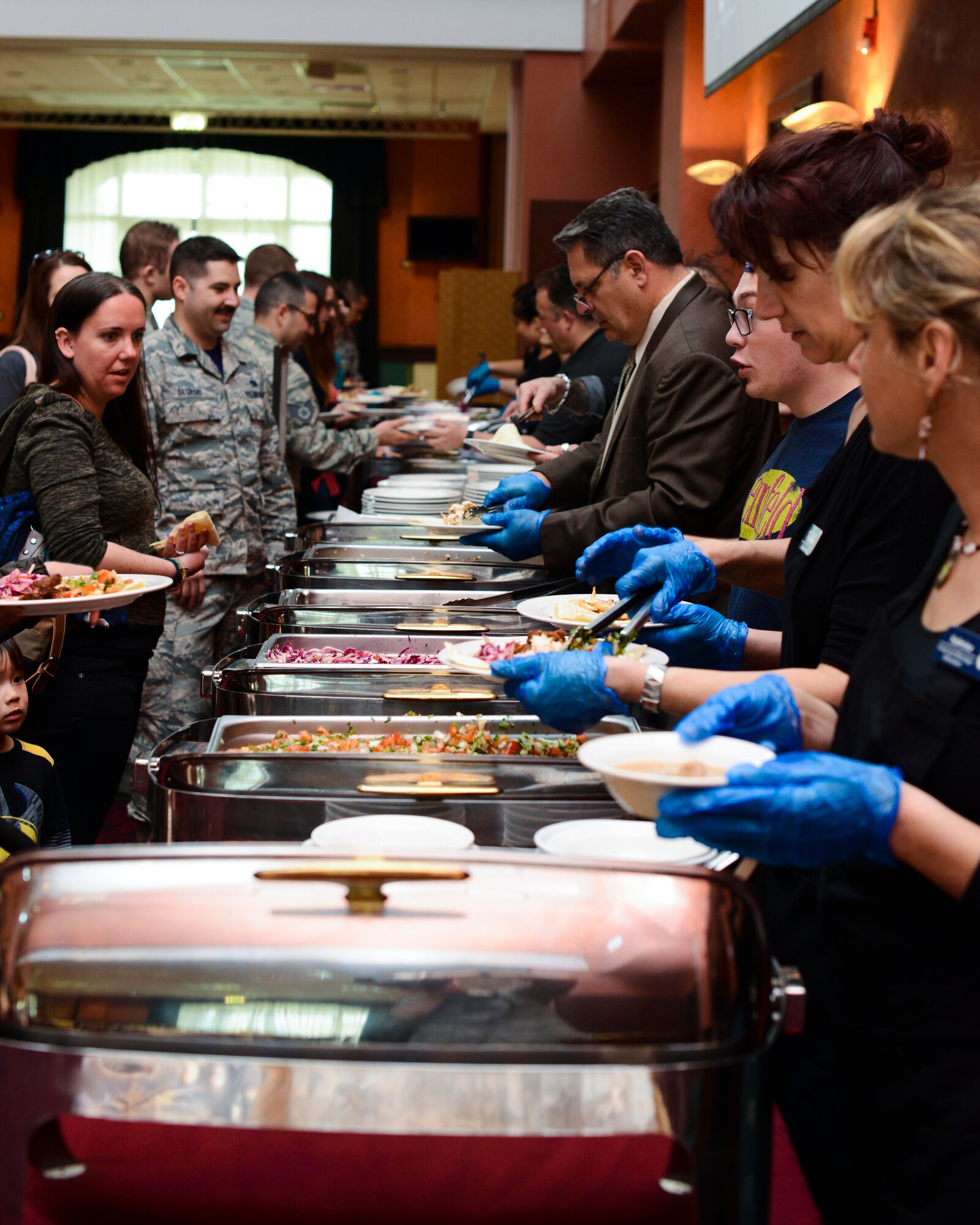 Aviano Wyverns line up for a Mexican-themed lunch, March 25, 2016, at Aviano Air Base, Italy. Chefs Sikey, Stretch and Gorilla Rich, three “Messlords” members, prepared the food for the Wyvern community. (U.S. Air Force photo by Senior Airman Austin Harvill/Released)