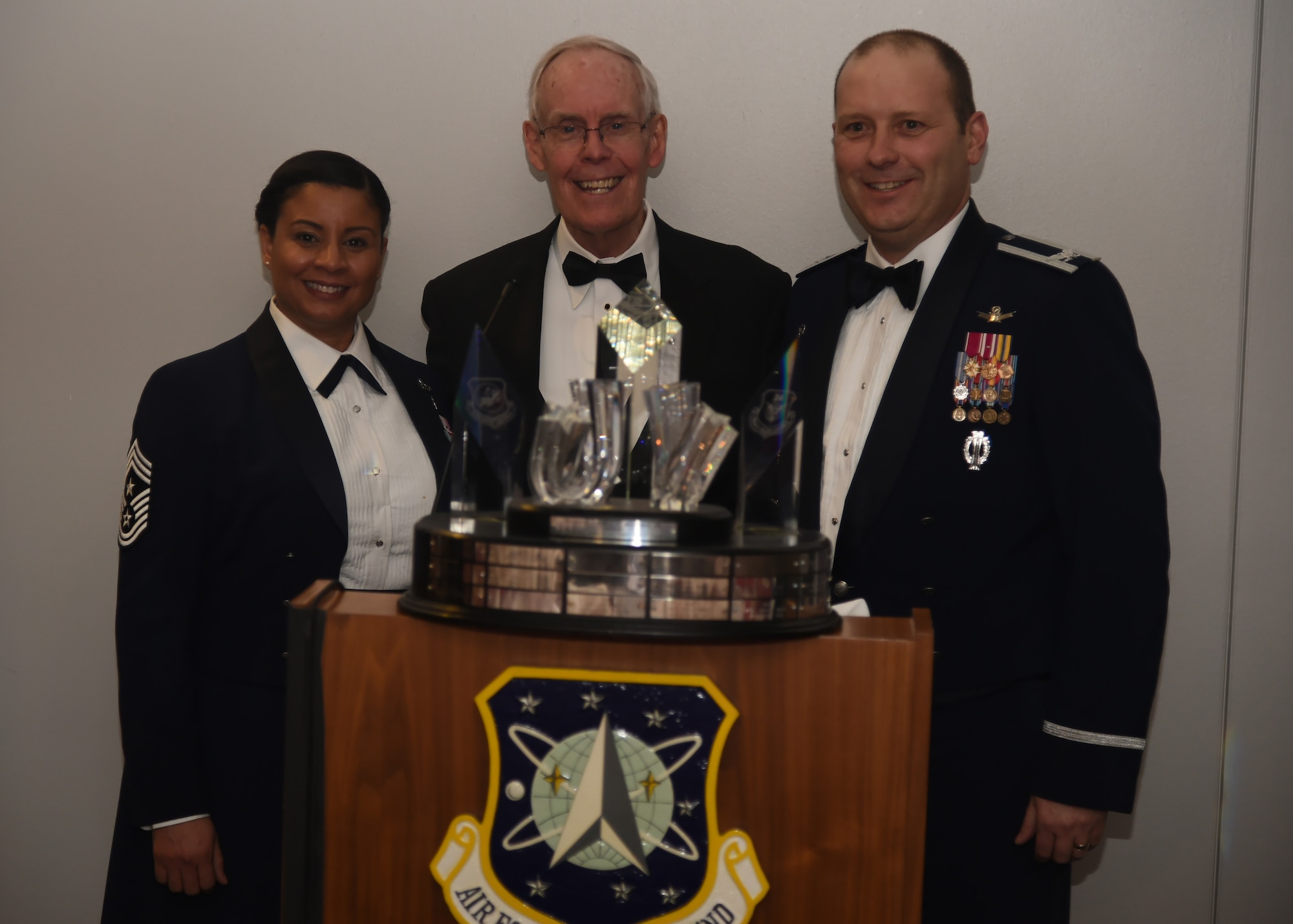 PETERSON AIR FORCE BASE, Colo. - Retired Gen. Thomas S. Moorman, Jr. (center), former Air force Space Command commander and vice chief of staff of the Air Force, presents Col. Douglas A. Schiess, 21st Space Wing commander, and Chief Master Sgt. Idalia Peele, 21st SW command chief, with the 2015 General Thomas S. Moorman, Jr. award on March 23, 2016. The annual award recognizes the best overall operational wing in Air Force Space Command. (U.S. Air Force photo by Senior Airman William Branch)