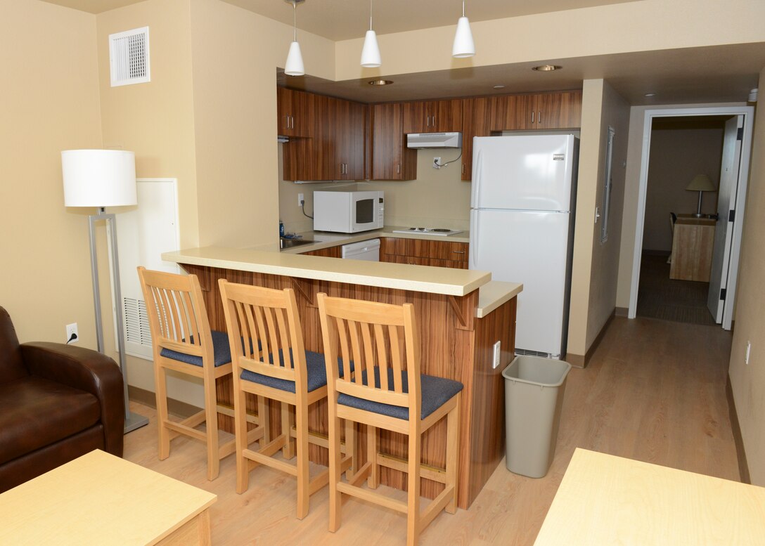 The kitchenette and common area of a three-bedroom suite in Dorm 2423. Air Force dormitory adequacy standards changed in 1996 to allow a room for every Airman with two Airmen sharing a bath and a kitchenette. In 2003, the current Dorms-4-Airmen standard was established to allow each resident a private room and bath in a suite setting. (U.S. Air Force photo by Kenji Thuloweit)