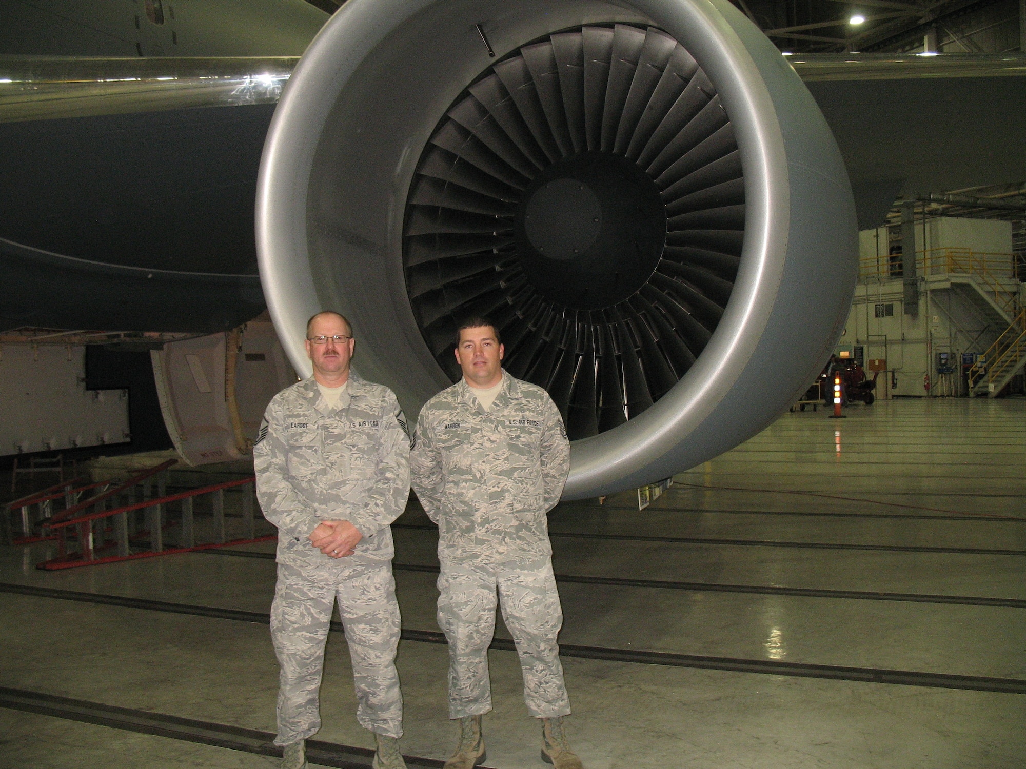 U.S. Air Force Master Sgt. Joel D. LaRose (left) and Tech. Sgt. Steven M. Warren pose for a photo in front of a KC-46 aircraft engine at Boeing near Seattle, Sept. 28, 2015. The Airman are part of the Air Force’s Tech Order Certification and Verification Team, for the KC-46 Pegasus. LaRose and Warren are assigned to the 157th Maintenance Group, Pease Air National Guard Base, New Hampshire.  (Courtesy photo, Boeing) 
