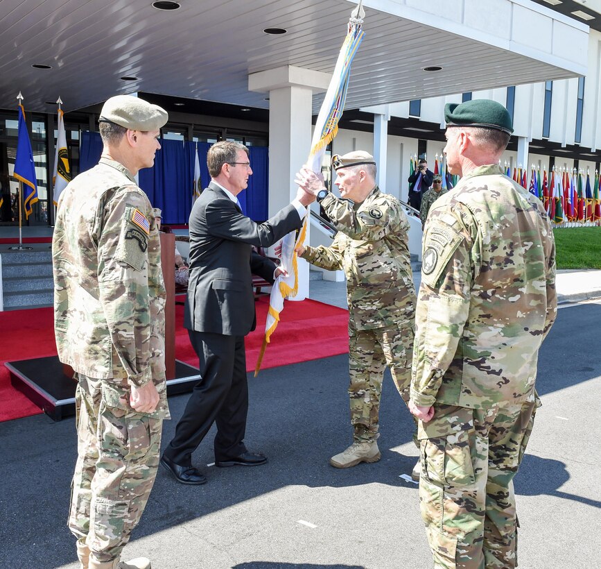 Defense Secretary Ash Carter passes the guidon for U.S. Special Operations Command to Army Gen. Raymond A. "Tony" Thomas, second from right, the incoming commander, as Army Gen. Joseph L. Votel, left, outgoing commander, during the Socom change-of-command ceremony at MacDill Air Force Base, Fla., March 30, 2016. DoD photo by Army Sgt. 1st Class Clydell Kinchen