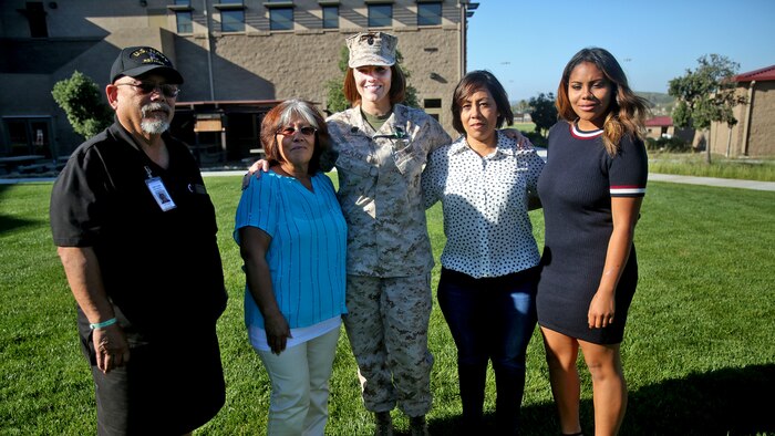 Chief Petty Officer Jaclyn Place poses for a photo with her neighbors and their family during Place’s award ceremony at Marine Corps Base Camp Pendleton, California, March 11, 2016. Place is a lead chief petty officer with the Headquarters Regimental Aid Station, 1st Marine Logistics Group, and was awarded an impact Navy and Marine Corps Commendation Medal for her selfless and decisive actions that saved the lives of her neighbors.