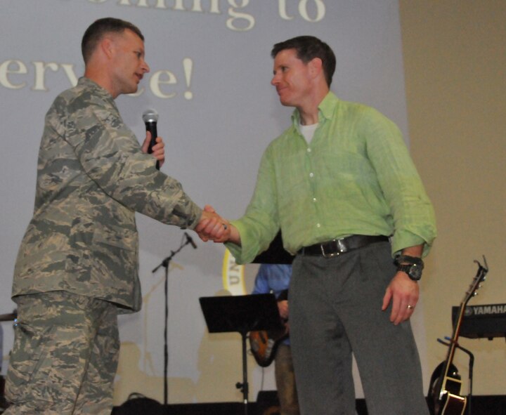 At the end of the Easter Sunday service, Chaplain (Maj. Gen.) Dondi Costin, Air Force Chief of Chaplains, coined Maj. Jeremiah Reed, Combined Air and Space Operations Center senior offensive duty officer, March 27 at Al Udeid Air Base, Qatar. Reed is the contemporary  protestant worship leader.  He partnered with Mr. Anthony Lamons, the gospel choir leader, melding two praise teams together for the Easter Sunday service. (U.S. Air Force photo by Tech. Sgt. Terrica Y. Jones)