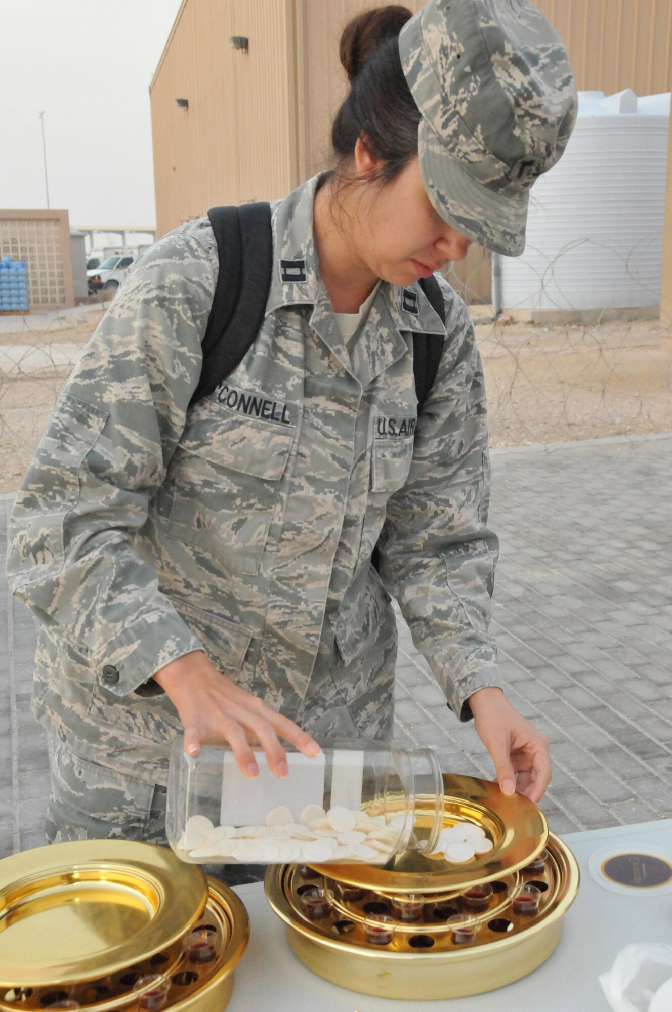 Chaplain (Capt.) Amy O’Connell, 379th Air Expeditionary Wing chaplain corps, prepares for communion March 27 at Al Udeid Air Base, Qatar. Attendees who desired to take communion were given the opportunity at the flight line Easter Sunrise Service held behind the multi-use hangar Sunday. Six worship opportunities were offered on Easter Sunday to include two Catholic Masses and a Church of Latter Day Saints Service. (U.S. Air Force photo by Tech. Sgt. Terrica Y. Jones)