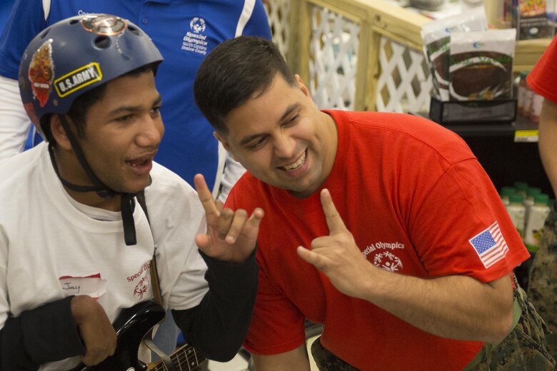 MARINE CORPS AIR STATION NEW RIVER, N.C. — Jay McMullen, a Special Olympic athlete, and Staff Sgt. Jason Cerre, a separations chief with Headquarters and Headquarters Support Squadron, rock out to “Crazy Train” during the games hosted by Marine Corps Air Station New River commissary Jan. 6. Jay told Cerre that he loves rock and roll, especially Ozzy Osborne and Metallica.