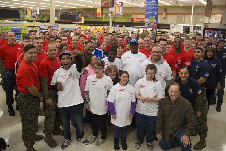 MARINE CORPS AIR STATION NEW RIVER, N.C. — Marines from Marine Corps Air Station New River and Special Olympics athletes from area pose for a group shot during an event hosted by the station commissary Jan. 6. The athletes competed in events including turkey bowling and a pie eating contest. 