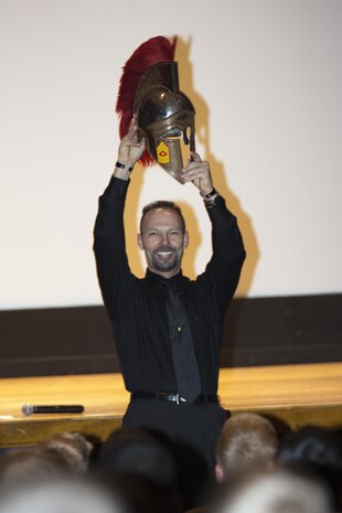 Todd Parisi, a retired sergeant major turned motivational speaker, lifts a Spartan helmet to the sounds of Marine war cries during his visit to Marine Corps Air Station New River Jan. 29. Parisi, who served 28 years in the Marine Corps and deployed multiple times during Operation Iraqi Freedom, spoke to young Marines about being good Marines and exceptional citizens.