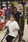 MARINE CORPS AIR STATION NEW RIVER, N.C. — Abigail Dingler, a Special Olympics athlete from Onslow County, and her Marine partner head to an event during the games hosted by the Marine Corps Air Station New River commissary Jan. 6. Each athlete was allowed to choose two Marines to participate in the games with them.