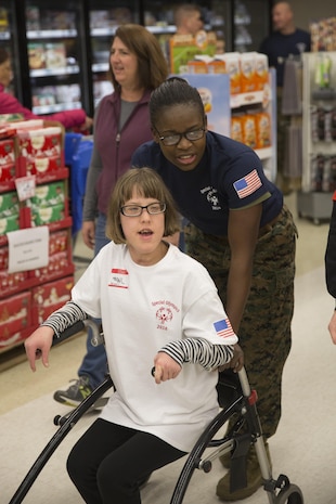 MARINE CORPS AIR STATION NEW RIVER, N.C. — Abigail Dingler, a Special Olympics athlete from Onslow County, and her Marine partner head to an event during the games hosted by the Marine Corps Air Station New River commissary Jan. 6. Each athlete was allowed to choose two Marines to participate in the games with them.