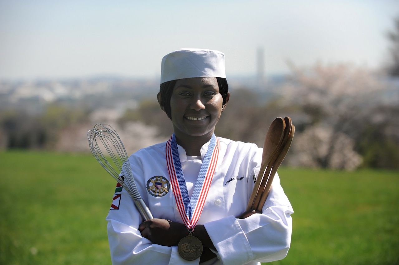 Navy Petty Officer 1st Class Frida Karani, 2016 Armed Forces Chef of the Year and personal chef for the vice chairman of the Joint Chiefs of Staff, poses with her tools of the trade near the vice chairman’s residence at Fort Myer, Virginia, March 24, 2016. DoD photo by Marvin Lynchard
