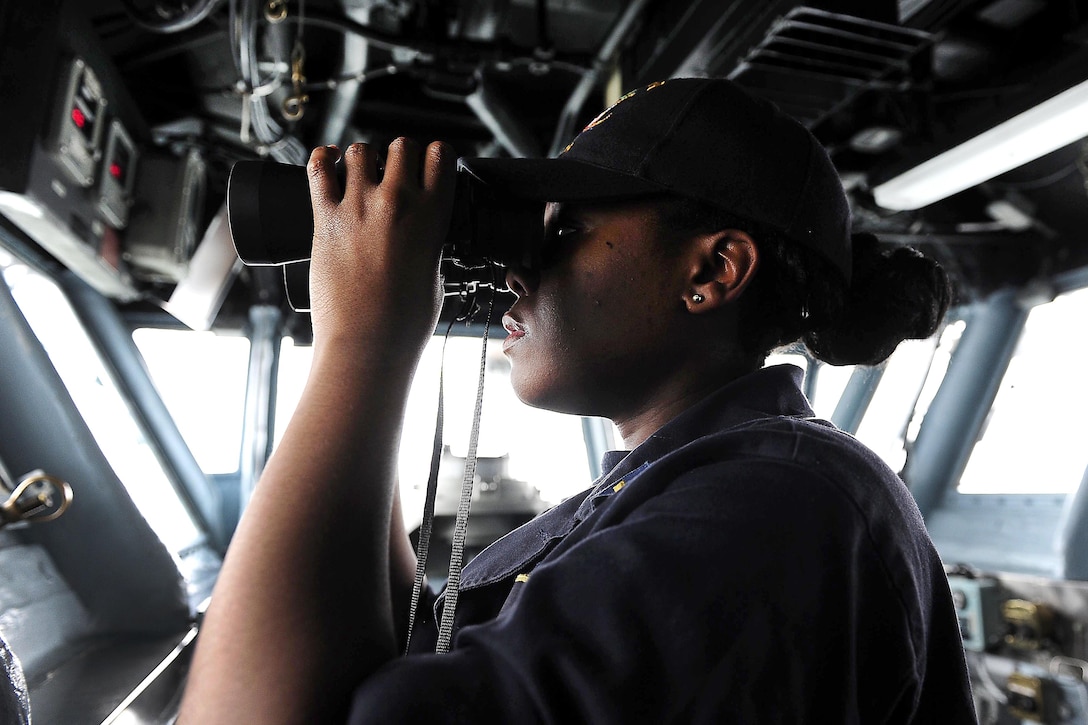 Navy Ensign Pauline Langston searches for surface contacts on the bridge of the amphibious assault ship USS Boxer at sea, March 21, 2016. Navy photo by Petty Officer 2nd Class Jose Jaen
