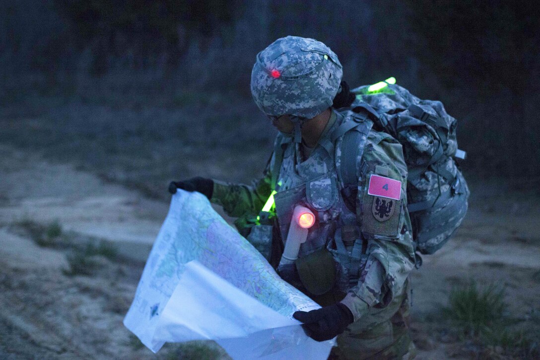 Army Sgt. Angel Hunter reads a map while participating in a night land-navigation event during the Best Warrior Competition at Fort Knox, Ky., March 22, 2016. Hunter is assigned to the 90th Aviation Support Battalion. Army photo by Spc. Gabriel Prado
