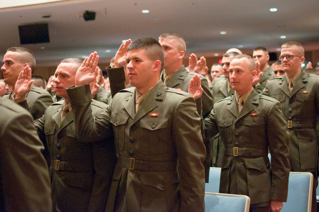 Marines raise their right hand to be commissioned as second lieutenants in a commissioning ceremony for Officer Candidate Class 221 at Little Hall aboard Marine Corps Base Quantico on March 26. The group takes the next step in their journey to be leaders of Marines