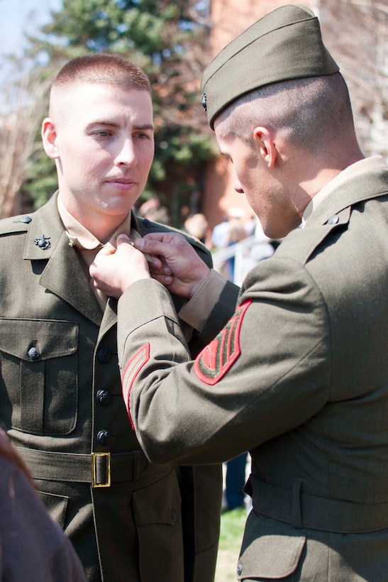 Staff Sgt. Sean Ferraro, a student in the Marine Corps Enlisted Commissioning Education Program, pins his classmate 2nd Lt. Cody Murphy, following the commissioning ceremony for Officer Candidate Class 221 at Little Hall aboard Marine Corps Base Quantico on March 26. The event included music by a live quartet from the Quantico Marine Corps Band.