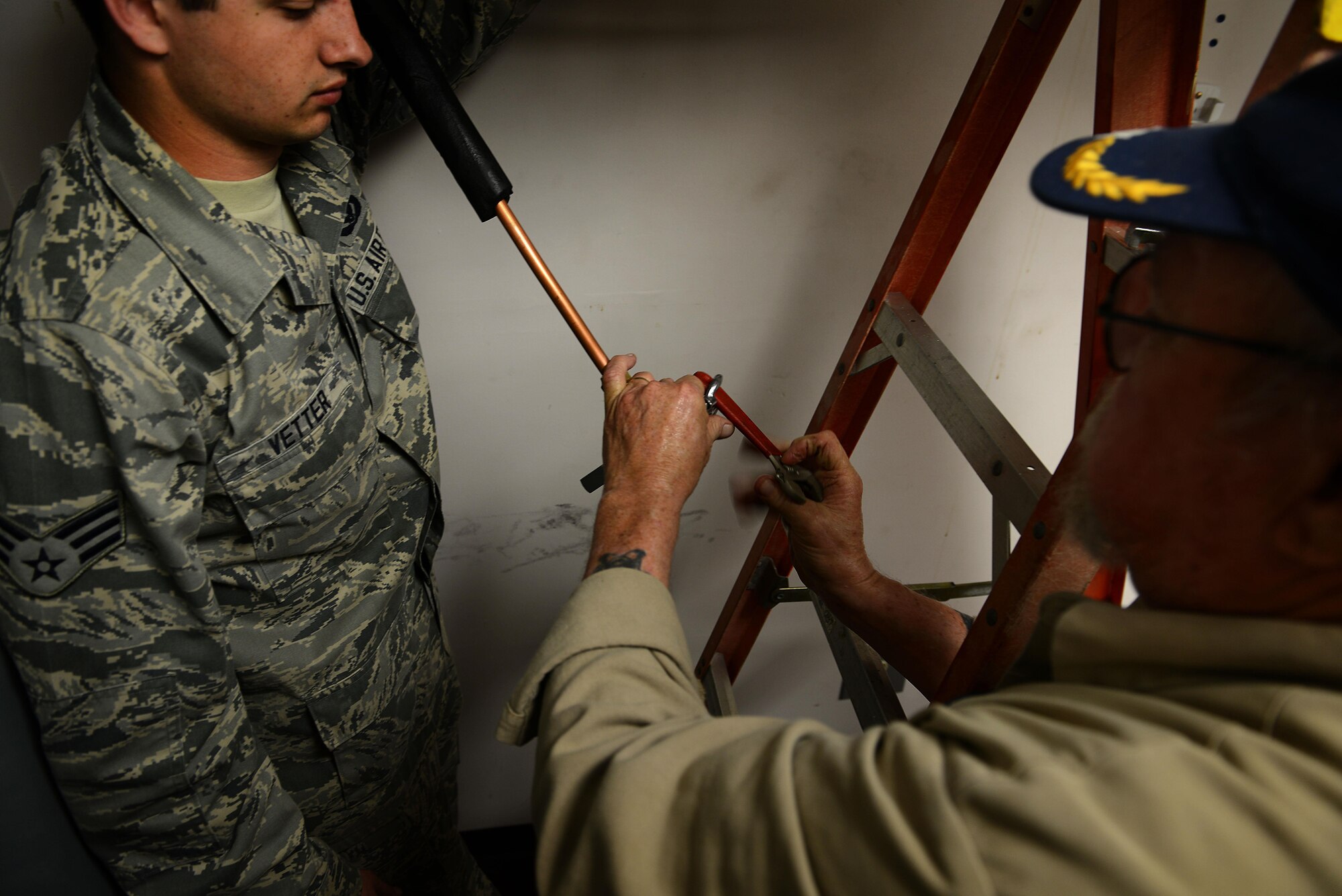 U.S. Air Force Senior Airman Darek Vetter 20th Civil Engineer Squadron heating, ventilation, and air conditioning technician, holds up a heating and air conditioning evaporator while Louis Lorick, 20th Civil Engineer Squadron HVAC technician, uses a flare kit tool to widen a copper pipe at Shaw Air Force Base, S.C., March 28, 2016. The HVAC shop maintains more than $30 million worth of units. (U.S. Air Force photo by Airman 1st Class Destinee Dougherty)