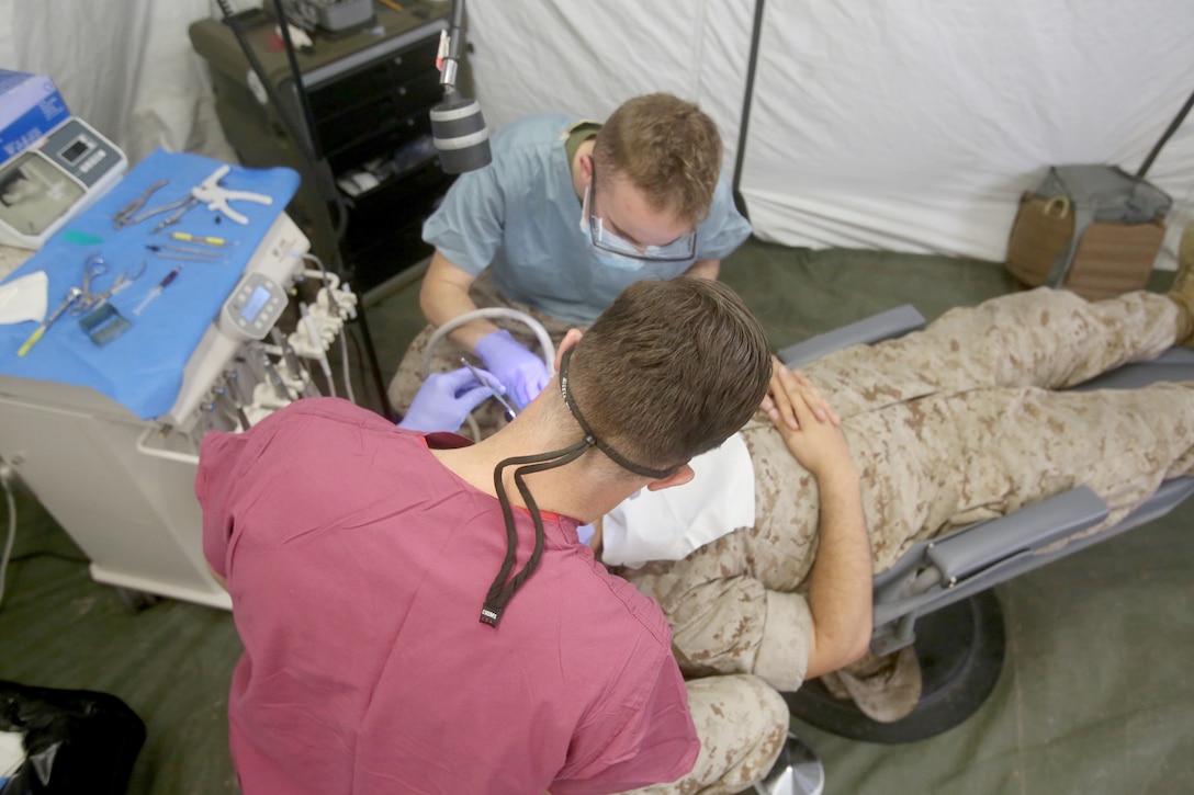 Lieutenant Matt Kanter, front, and Seaman Jeremy Fickle treat a patient during Authorized Dental Allowance List Exercise aboard Camp Pendleton, Calif., March 13-25, 2016. Kanter is a dental officer and Fickle is a dental corpsman, both with 1st Dental Battalion, 1st Marine Logistics Group. ADALEX, which is being conducted for the first time in 10 years, is intended to increase the unit’s expeditionary dental capabilities by operating in a field environment.  (U.S. Marine Corps photo by Cpl. Carson Gramley/released)