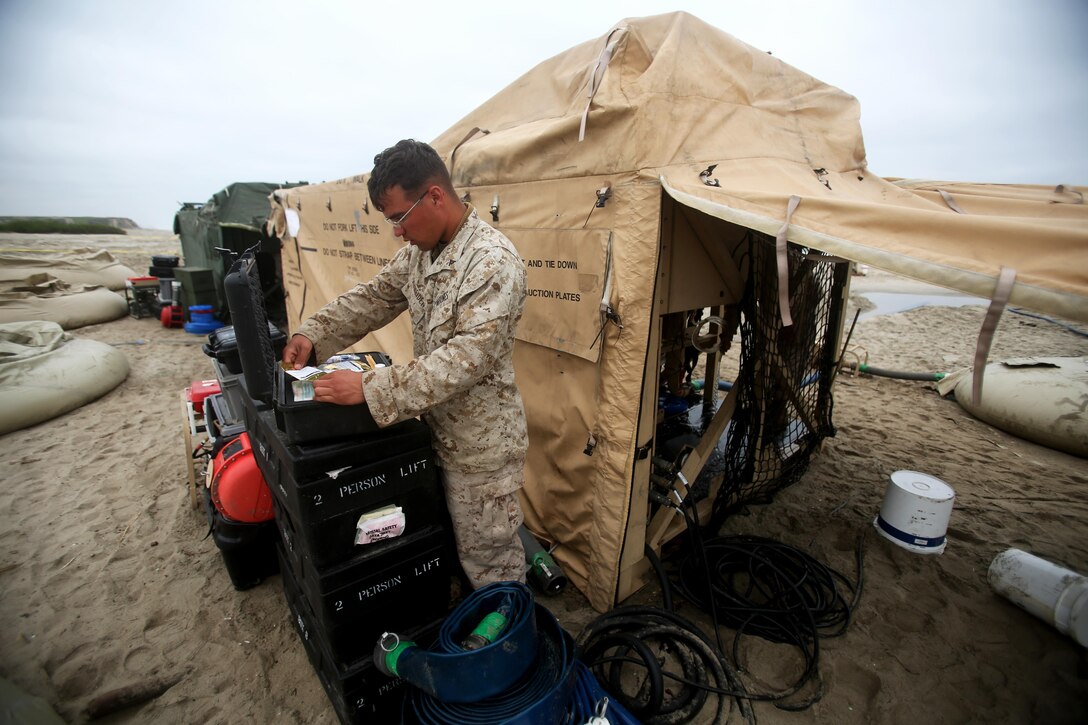 Corporal Tyler Schneider, a water support technician with Utilities Platoon, Headquarters and Support Company, 7th Engineer Support Battalion, 1st Marine Logistics Group, retrieves the required supplies to maintain a tactical water purification system during a utilities exercise at Red Beach aboard Camp Pendleton, Calif., March 21, 2016. Utilities Platoon conducted an eight-day field exercise which focused on their ability to provide clean water and stable power to a unit located in an environment without standard utility resources. (U.S. Marine Corps photo by Cpl. Carson Gramley/released)