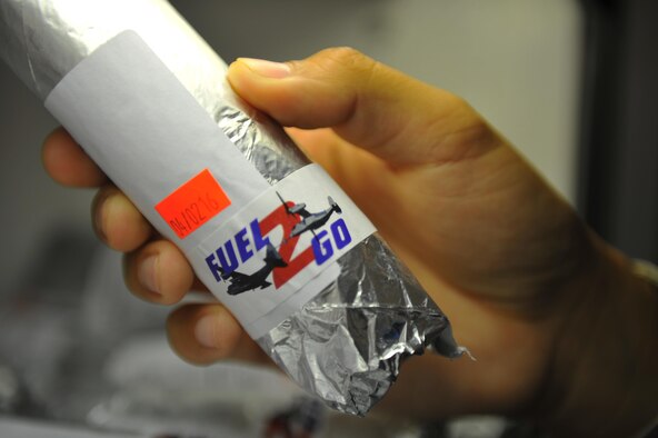 Senior Airman Jonathan Hair, a fitness specialist with the 1st Special Operations Force Support Squadron, inspects the expiration date of a chicken wrap at the Aderholt Fitness Center, Hurlburt Field, Fla., March 30, 2016. The “Fuel 2 Go” snack bar opened March 30 and offers a variety of wraps, salads and parfaits. (U.S. Air Force photo by Airman 1st Class Joseph Pick)