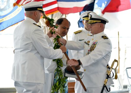 160330-N-LY160-308
JOINT BASE PEARL HARBOR-HICKAM, Hawaii (March 30, 2016) Commander William A. Patterson, right, presents ihe koa, a ceremonial warrior spear, to Cmdr. John C. Roussakies, commanding officer of the Virginia-class fast-attack submarine USS Hawaii (SSN 776), under the blessing from Kahu Kordell Kekoa during a change of command ceremony at the Battleship Missouri Memorial. (U.S. Navy photo by Mass Communication Specialist 2nd Class Michael H. Lee/Released)