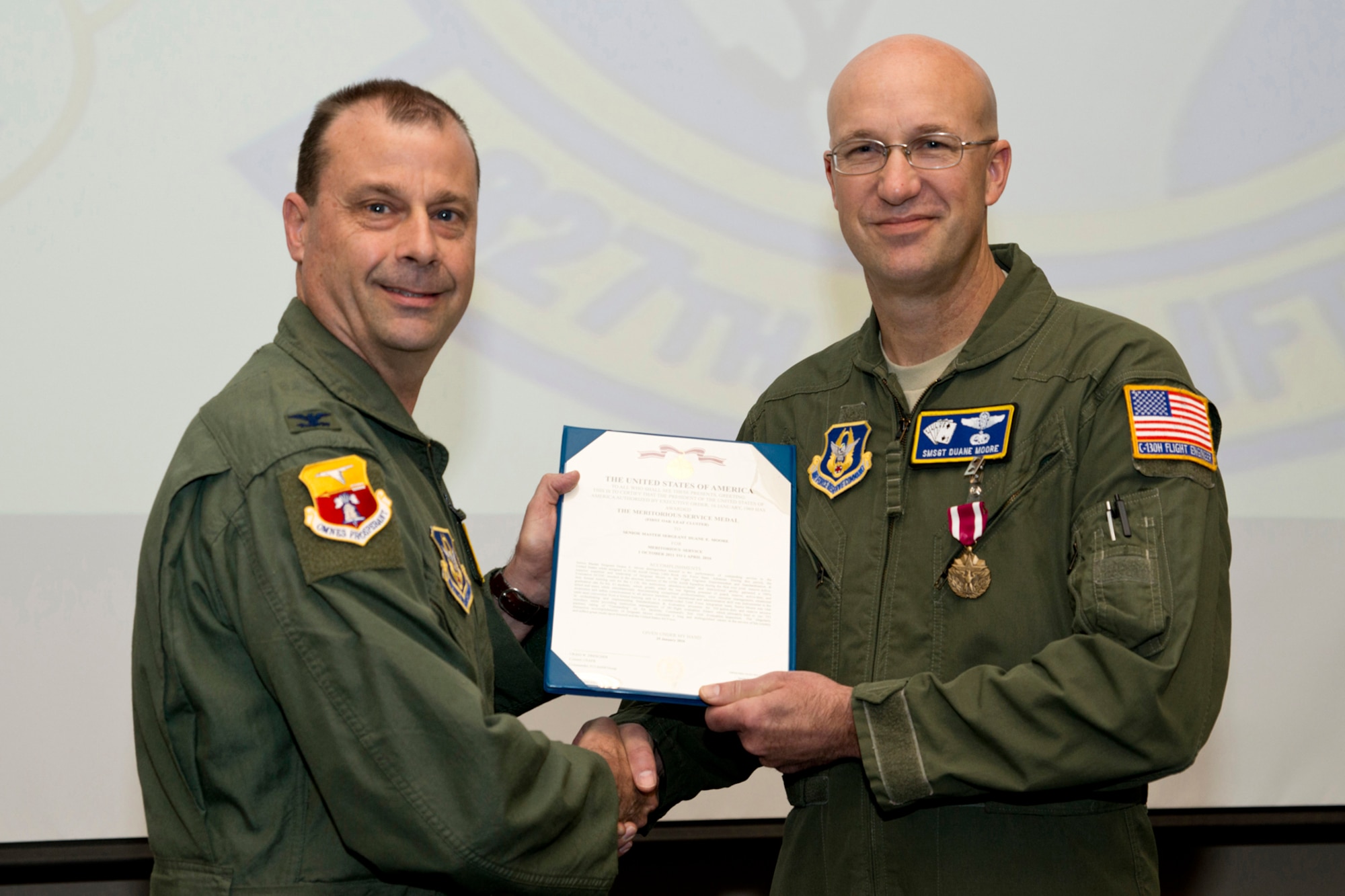 U.S. Air Force Reserve Col. Craig Drescher, commander, 913th Airlift Group, and Senior Master Sgt. Duane Moore, flight engineer, 327th Airlift Squadron, pose for a photo at Little Rock Air Force Base, Ark., Mar. 31, 2016. Moore was awarded the Air Force Meritorious Service Medal for outstanding service to the 913 AG from 1 October 2011 to 1 April 2016. He retires on Apr. 1, 2016, after more than 30 years, seven months and eight days of military service. (U.S. Air Force photo by Master Sgt. Jeff Walston/Released) 