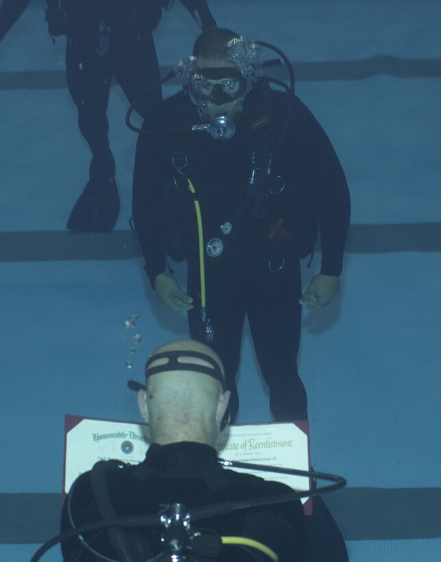 A Marine Raider with Marine Raider Regiment, U.S. Marine Corps Forces, Special Operations Command (MARSOC) conducts his re-enlistment ceremony while submerged underwater at the MARSOC dive tank, aboard Stone Bay, Marine Corps Base Camp Lejeune, N.C., March 31, 2016.  (U.S. Marine Corps Photo by Sgt. Scott A. Achtemeier / Released) 