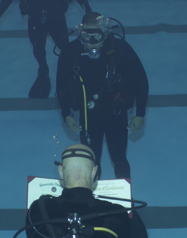 A Marine Raider with Marine Raider Regiment, U.S. Marine Corps Forces, Special Operations Command (MARSOC) conducts his re-enlistment ceremony while submerged underwater at the MARSOC dive tank, aboard Stone Bay, Marine Corps Base Camp Lejeune, N.C., March 31, 2016.  (U.S. Marine Corps Photo by Sgt. Scott A. Achtemeier / Released) 