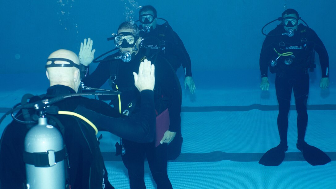 A Marine Raider with Marine Raider Regiment, U.S. Marine Corps Forces, Special Operations Command (MARSOC) recites the oath of enlistment during his re-enlistment ceremony, while submerged underwater at the MARSOC dive tank, aboard Stone Bay, Marine Corps Base Camp Lejeune, N.C., March 31, 2016. (U.S. Marine Corps Photo by Sgt. Scott A. Achtemeier / Released) 
