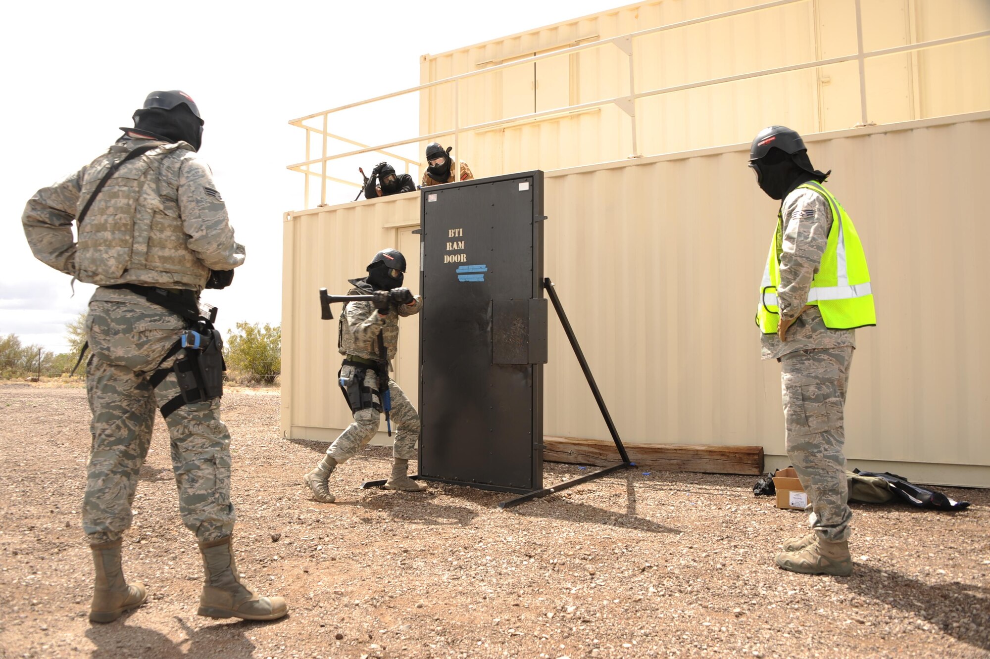 U.S. Air Force Senior Airman Anthony Fernandez, 355th Communications Squadron network technician, breaks through a barricade while participants observe during the Comprehensive Airman Fitness Month Defender Challenge held by the 355th Security Forces Squadron at Davis-Monthan Air Force Base, March 31, 2016. Each team consisting of two participants went through the same hostage recovery scenario and were scored on speed and accuracy. (U.S. Air Force photo by Airman Nathan H. Barbour/Released)