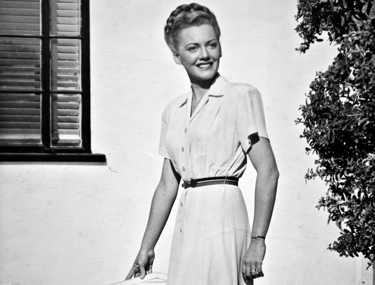 Betty Blake, 20 years old, stands in front of her family's home in Honolulu, Hawaii. Blake worked at the captain of the Navy yard's office and also flew tourists around the Hawaiian Islands as a commercial pilot before the attack on Pearl Harbor.  (U.S. Air Force photo by Tech. Sgt. Bennie J. Davis III)