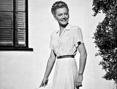 Betty Blake, 20 years old, stands in front of her family's home in Honolulu, Hawaii. Blake worked at the captain of the Navy yard's office and also flew tourists around the Hawaiian Islands as a commercial pilot before the attack on Pearl Harbor.  (U.S. Air Force photo by Tech. Sgt. Bennie J. Davis III)