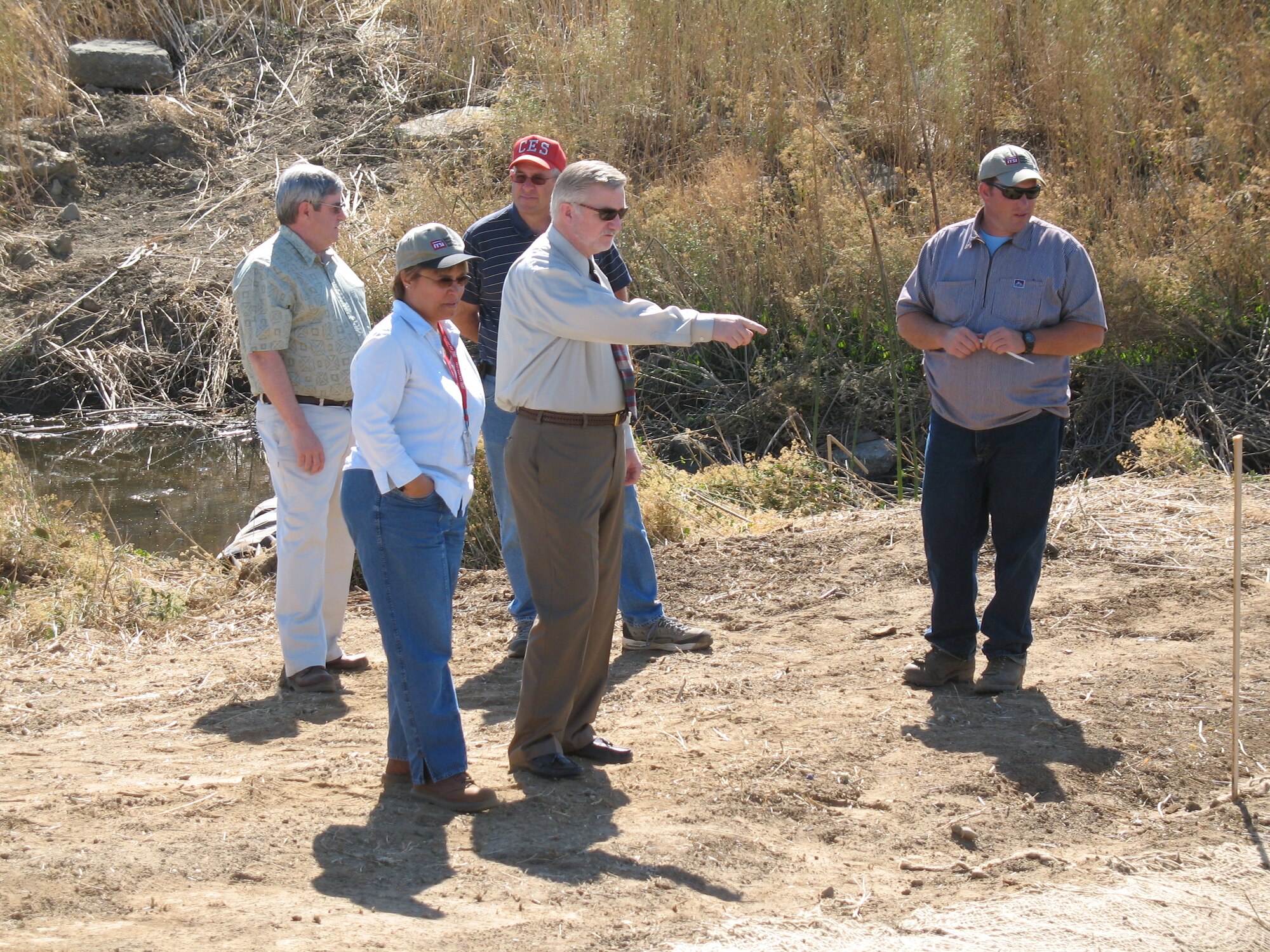Mark Smith, center, describes sediment cleanup work to community members during an environmental restoration program tour. Until his retirement, April 1, Smith had managed the base’s environmental restoration program for more than 13 years, which included managing the multimillion dollar contracts to cleanup soil and groundwater contamination at Travis Air Force Base, California.  (Courtesy photo Glenn Anderson).