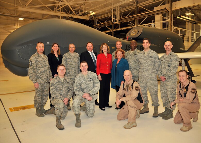Lisa Disbrow, Undersecretary of the Air Force, center left, and North Dakota U.S. Senator Heidi Heitkamp, center right, with Members of the 319th Air Base Wing and also along with members of the U.S. Customs and Border Patrol, pose for a group photo during a base tour on March 30, 2016, at Grand Forks Air Force Base, N.D. The base tour consisted of Radar Approach Control (RAPCON) tower and a Block 40 RQ-4 Global Hawk brief. (U.S. Air Force photo by Senior Airman Xavier Navarro) 
