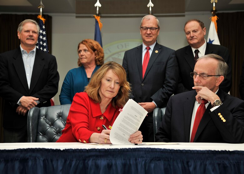 Lisa Disbrow, Undersecretary of the Air Force, left, and Tom Falck, Grand Forks County Commissioner, right, sign the Joint Use Agreement between the U.S. Air Force and Grand Forks Country March 30, 2016, at Grand Forks Air Force Base, N.D. This agreement allows the county and its partners to use the runway on Grand Forks AFB. (U.S. Air Force photo by Senior Airman Xavier Navarro)