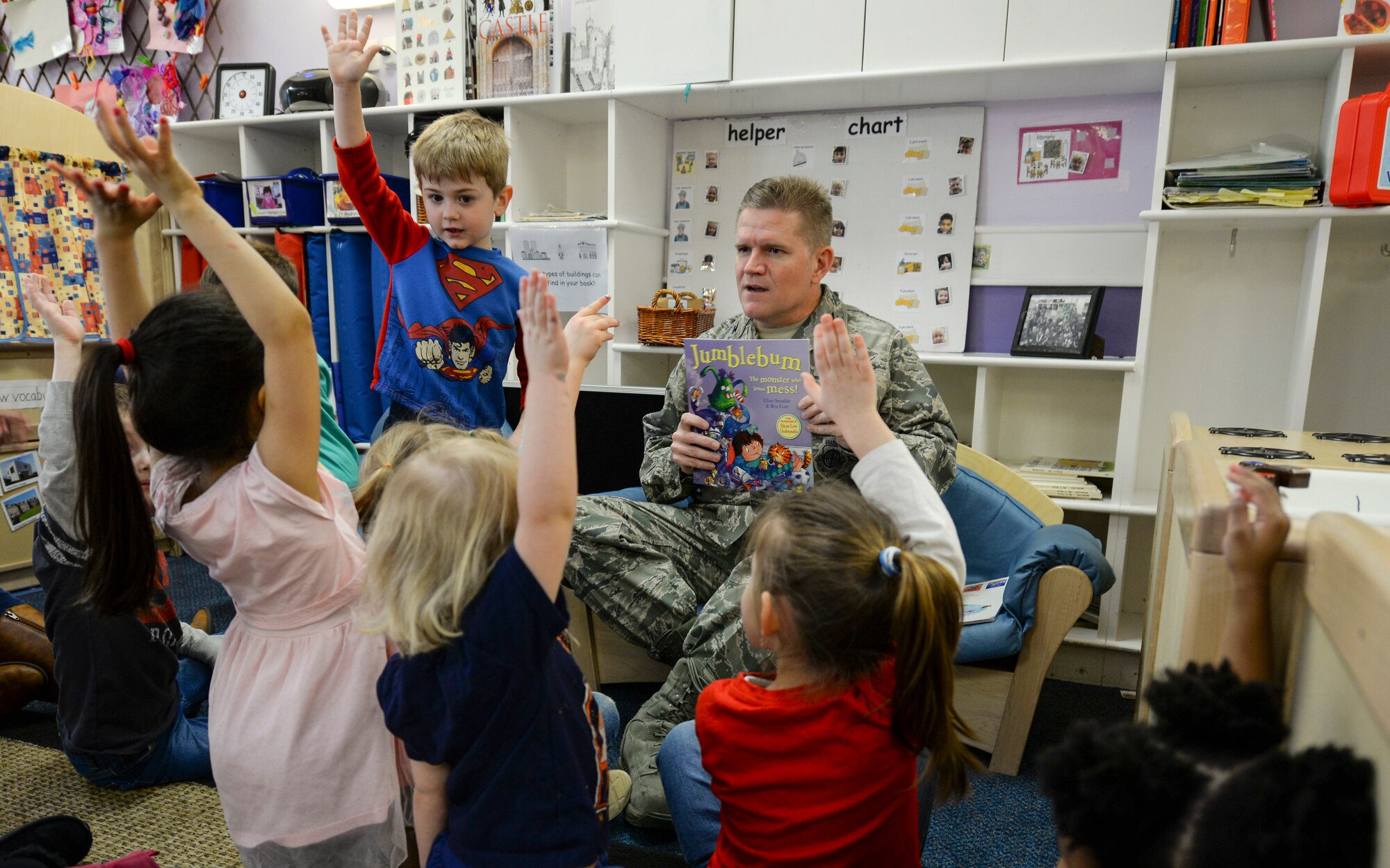 U.S. Air Force Col. Thomas D. Torkelson, 100th Air Refueling Wing commander, asks children which book they want him to read at the Child Development Center March 29, 2016, on RAF Mildenhall, England. Throughout the month of March the CDC is celebrating Dr. Seuss’ birthday by inviting members of Team Mildenhall to read to children and encouraging good reading habits. (U.S. Air Force photo by Staff Sgt. Micaiah Anthony/Released)