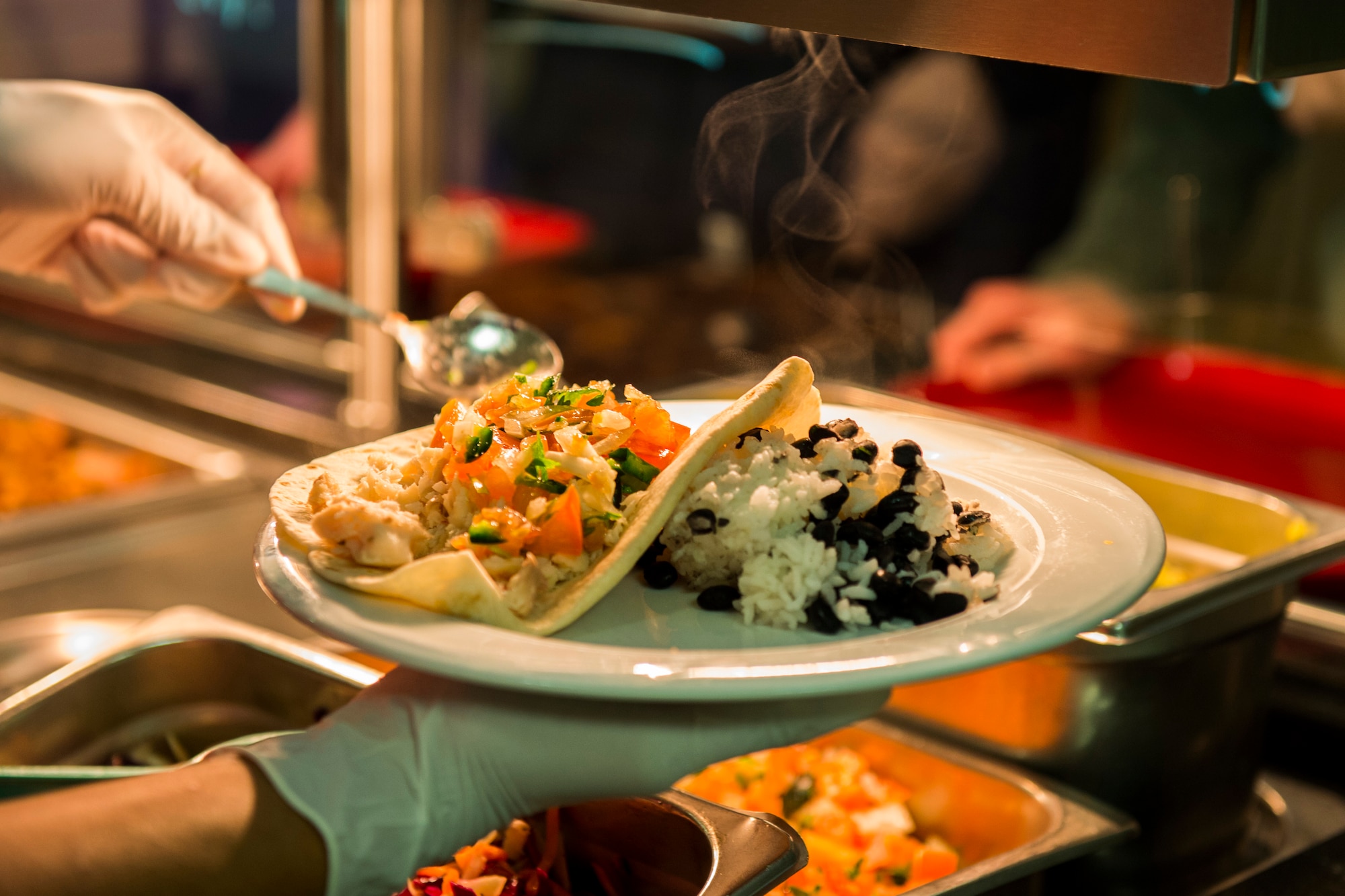 A member of the 52nd Force Support Squadron puts together a plate of food during the Messlords luncheon at the Mosel Dining Facility at Spangdahlem Air Base, Germany, March 30, 2016. The culinary creations of the Messlords included a green chili with pork, marinated fish tacos, rice, beans, homemade guacamole and pico de gallo. (U.S. Air Force photo by Senior Airman Luke Kitterman/Released)
