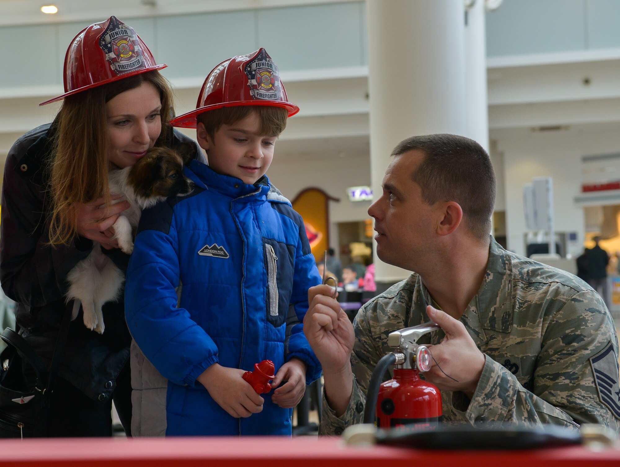 Master Sgt. Mark Goenen, 86th Civil Engineer Squadron fire prevention supervisor, teaches a boy how to operate a fire extinguisher at a fire safety kiosk March 25, 2016, at Ramstein Air Base, Germany. The kiosk kicked off the “Spring Into Fire Safety” campaign that’s intended to teach people the fire hazards that come with the spring season. (U.S. Air force photo/Airman 1st Class Lane T. Plummer)
