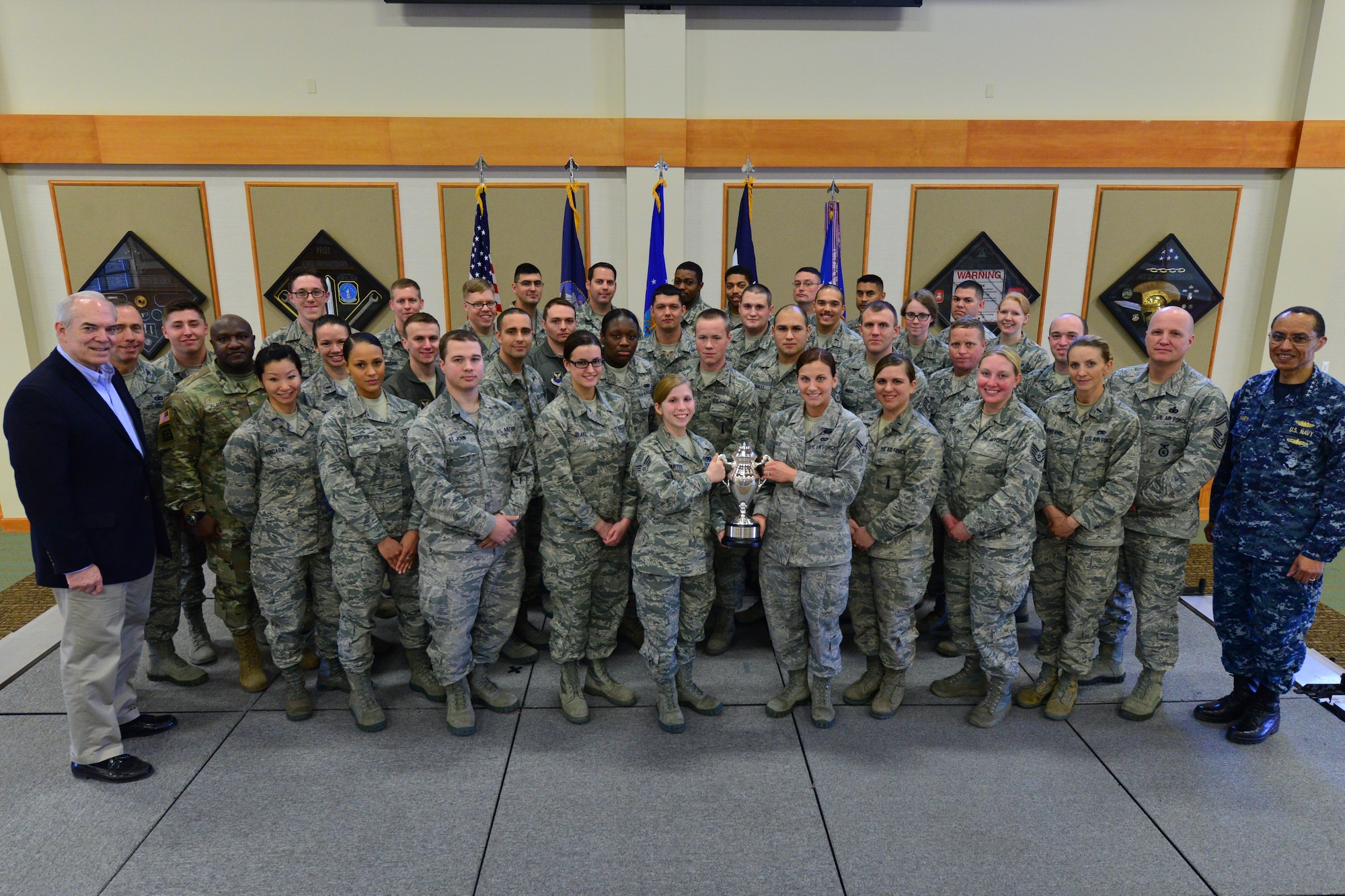 U.S. Navy Adm. Cecil D. Haney, U.S. Strategic Command (USSTRATCOM) commander (right); U.S. Army Command Sgt. Maj. Patrick Z. Alston, USSTRATCOM senior enlisted leader (fourth from left); and Mr. David G. Brown, Strategic Command Consultation (SCC) Committee member (left), pose for a photo with Airmen after an award ceremony honoring the 341st Missile Wing at Malmstrom Air Force Base, Mont., March 30, 2016. During the ceremony, Haney and Brown presented the 2015 Omaha Trophy, ICBM category, to U.S. Air Force Col. John T. Wilcox II, 341st Missile Wing commander (not pictured) and Team Malmstrom, in recognition of the wing's contributions to USSTRATCOM's global strategic missions. The Omaha Trophy, which was originally created by the SCC in 1971, was presented to the wing in recognition of their contributions to USSTRATCOM's global strategic missions. At the time, a single trophy was presented annually as a token of appreciation to USSTRATCOM's best wing. Since then, the tradition has evolved to unit-level awards that recognize the command's premier ICBM wing, ballistic missile submarine, strategic bomber wing and global operations (space/cyberspace) unit. This year, a new category was added to include the combatant command's top strategic aircraft wing. (U.S. Air Force photo by Airman Daniel Brosam)