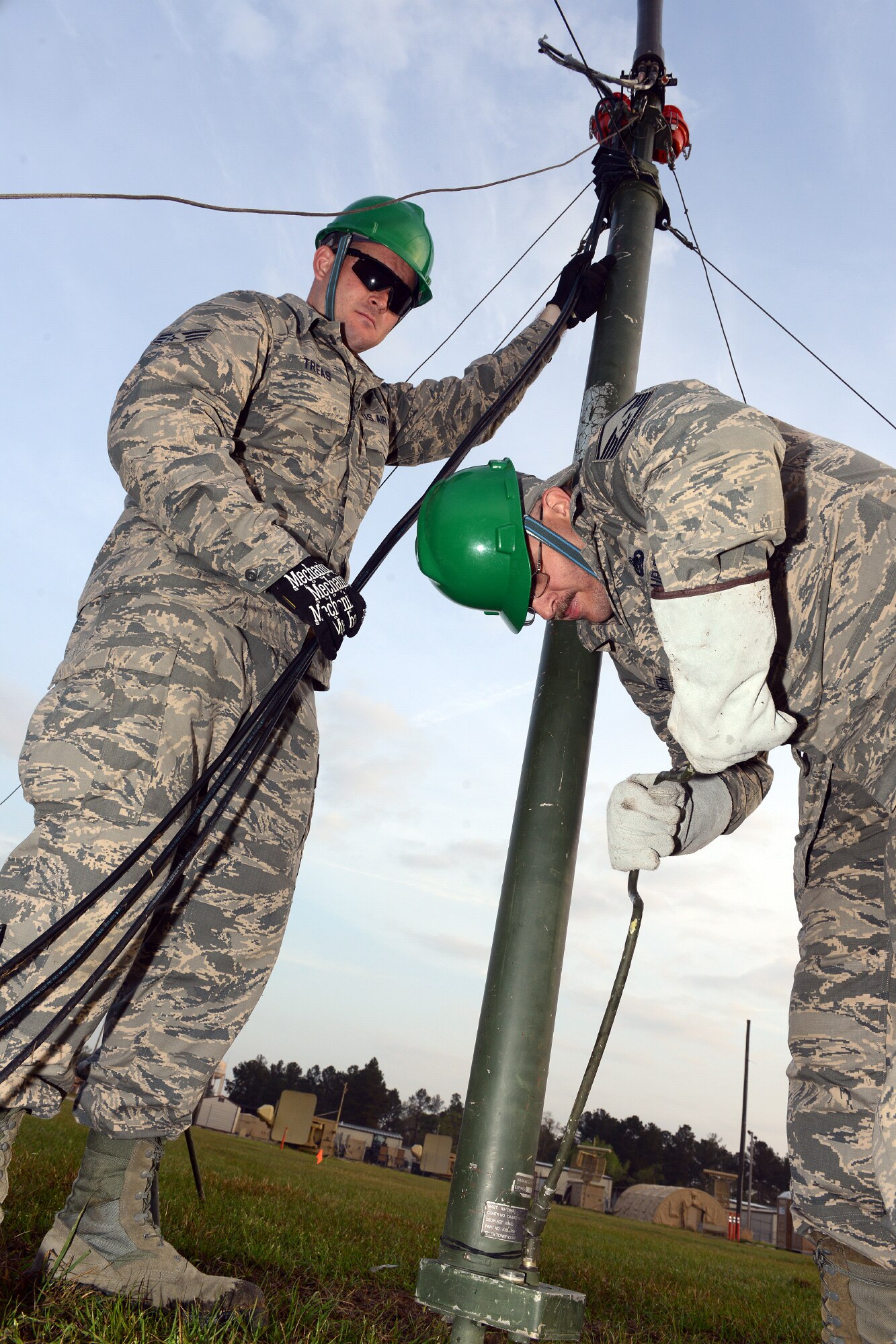 Senior Airman John Treas, left, airfield systems technician, assists Master Sgt. Jeremy Green, quality assurance, set up a ground to air antennae in a training area near Warrior Air Base, March 17, 2016. (U.S. Air Force photo by Tommie Horton)