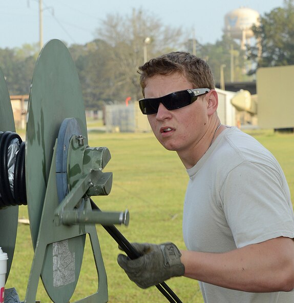 Senior Airman Adam Spittle, airfield systems technician, runs cable for the land mobile radio, March 17, 2016. (U.S. Air Force photo by Tommie Horton)