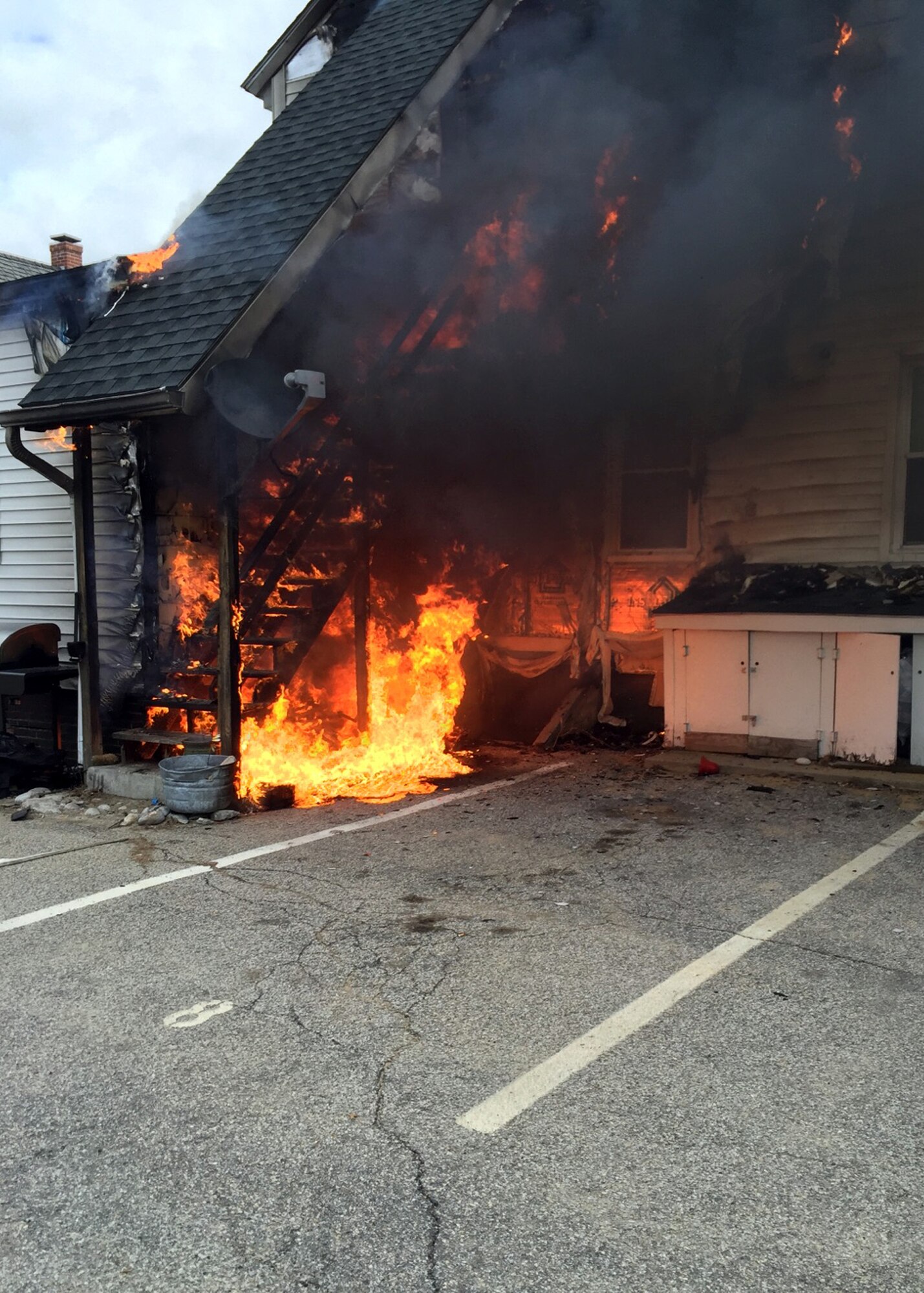 A fire burns outside an apartment building earlier this week in Concord, N.H. Sean Ford, a Hanscom firefighter, after noticing smoke billowing from behind the building while passing by in his vehicle, entered the three-story apartment building to help residents. Photo by Sean Ford)


