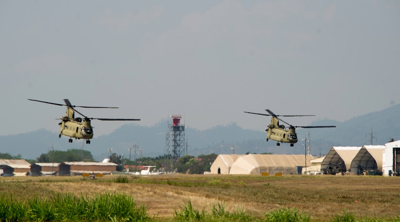 Two U.S. Army CH-47 Chinooks depart Soto Cano Air Base in support of firefighting efforts on the North coast of Honduras, Mar. 31, 2016, after Juan Orlando Hernandez, President of Honduras, sent a request for support to the U.S. Ambassador in Honduras. The helicopters, assigned to the 1-228th Aviation Regiment, maintain a Bambi Bucket capability, allowing them to support Honduran fire response forces fighting fires like those affecting the Jeanette Kawas National Park in northern Honduras. (U.S. Army photo by Martin Chahin/Released)