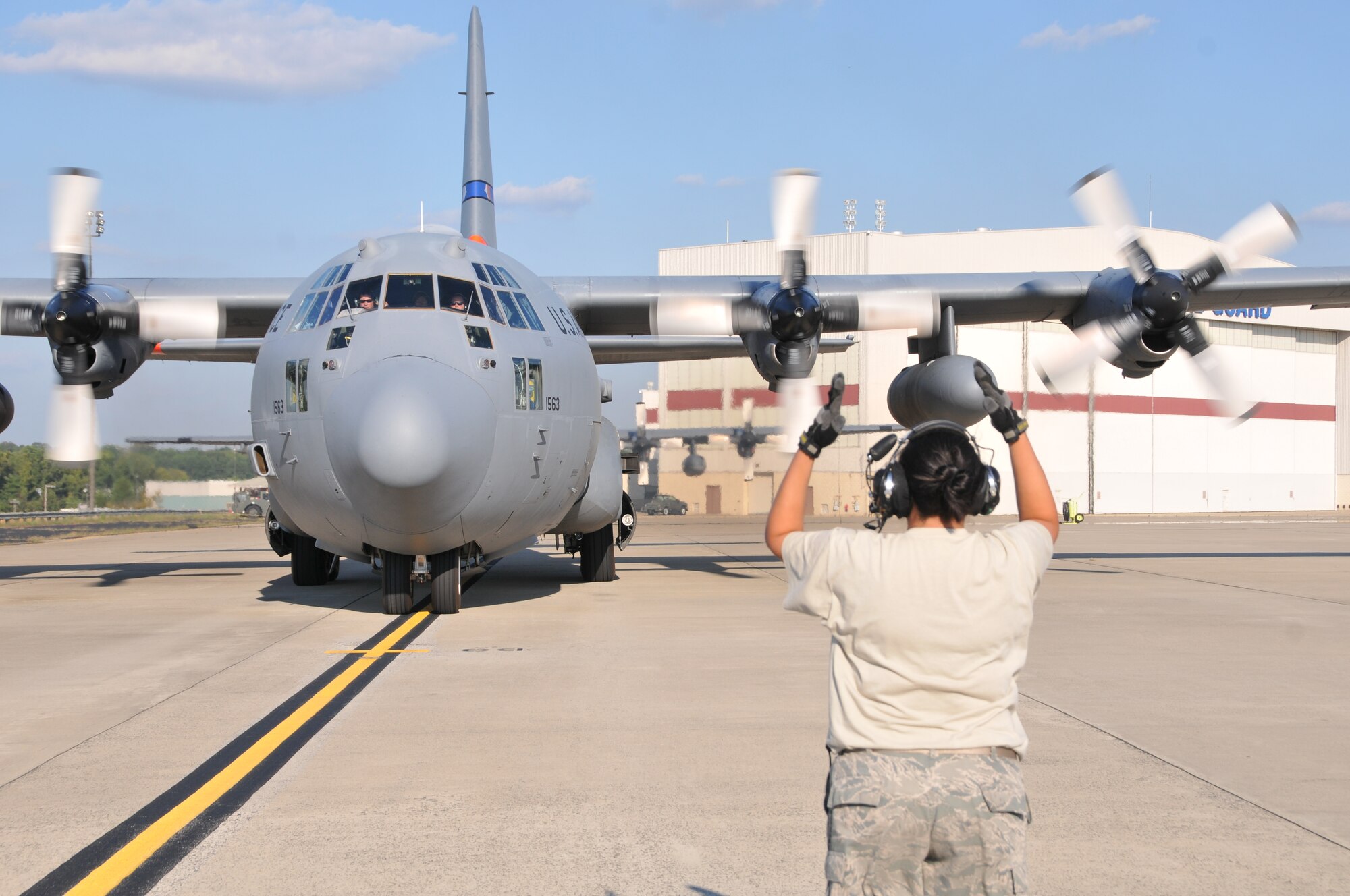 U.S. Air Force Master Sgt. Megan Delgado-Wahl, crew chief for the 145th Aircraft Maintenance Squadron, marshals aircrew onboard a 145th Airlift Wing, C-130 Hercules aircraft as it taxies out to runway at the North Carolina Air National Guard Base, Charlotte Douglas International Airport, Sept. 9, 2013. (U.S. Air National Guard photo by Master Sgt. Richard Kerner, 145th Public Affairs/Released)