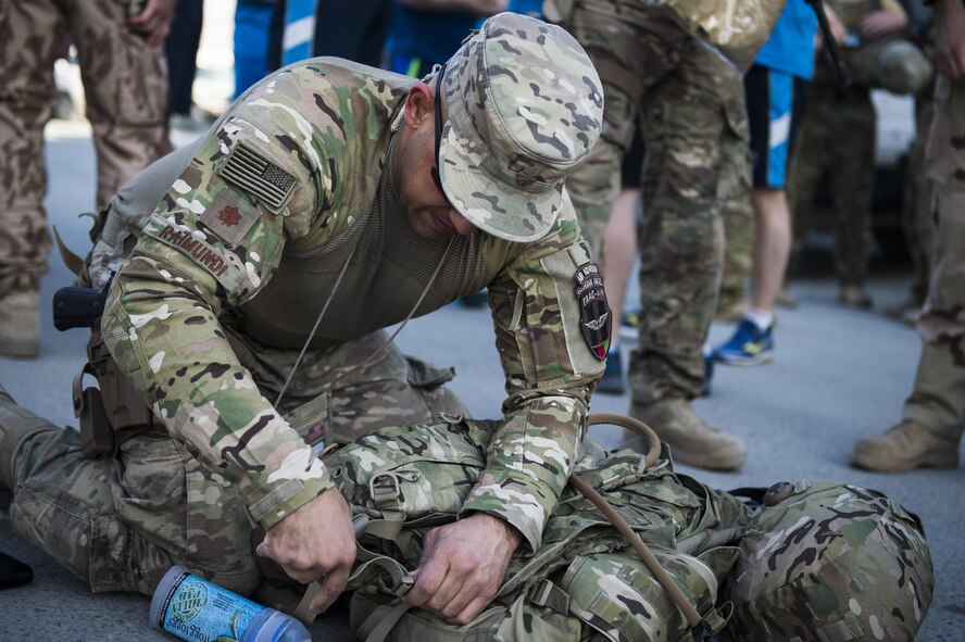 U.S. Air Force Maj. Jesus Raimundi adjusts his gear before the Train, Advise, Assist Command-Air's (TAAC-Air) annual remembrance ruck, run and walk in Kabul, Apr. 27, 2016. The ruck, run and walk honored the nine Airmen who were shot and killed on the TAAC-Air compound on April 27, 2011, along with two Airmen assigned to the command, who lost their lives in a helicopter crash on October 11, 2015.(U.S. Air Force photo/Staff Sgt. Larry E. Reid Jr., Released) 