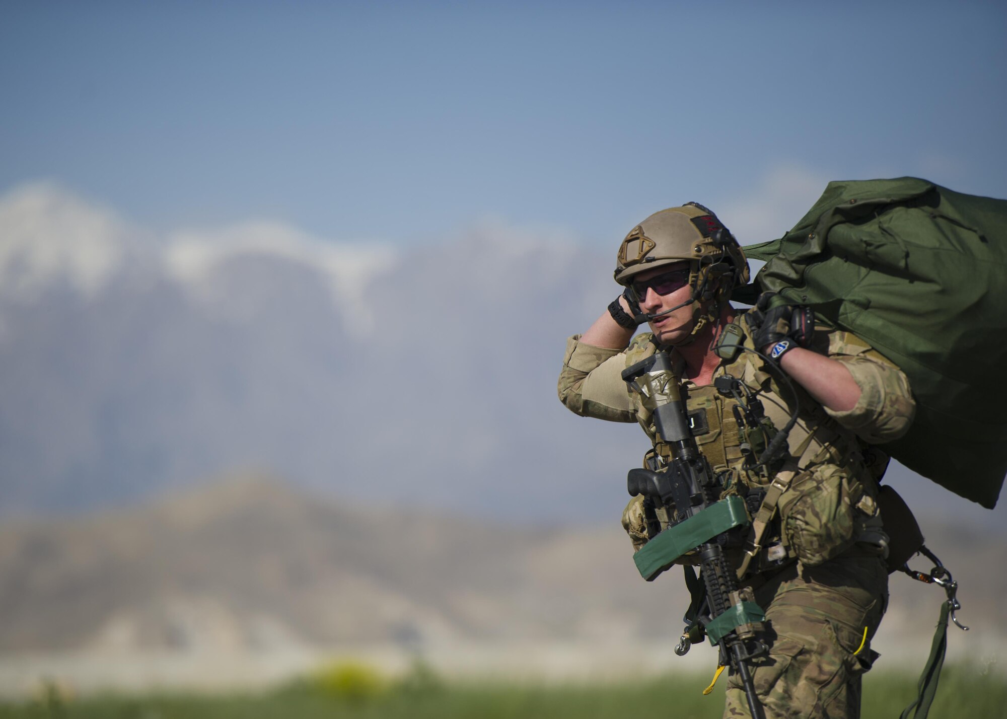A pararescueman from the 83rd Expeditionary Rescue Squadron hauls his parachute after jumping from a C-130J Super Hercules during a mission rehersal at Bagram Airfield, Afghanistan, April 28, 2016. This mission rehearsal is key to ensure pararescuemen are ready for real world missions throughout Afghanistan. (U.S. Air Force photo by Technical Sgt. Robert Cloys)
