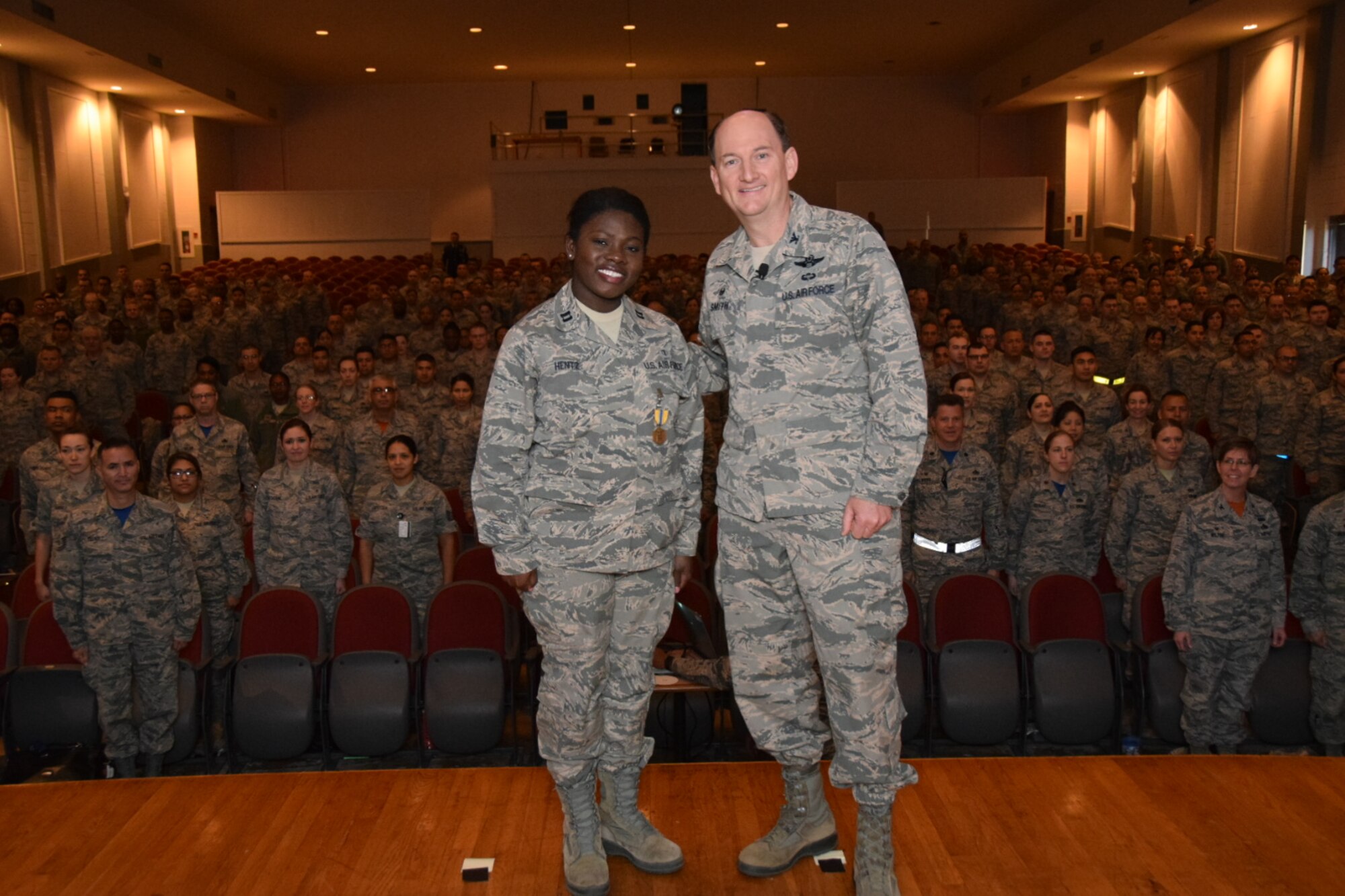 Col. Thomas K. Smith Jr., 433rd Airlift Wing commander, right, congratulates Capt. Gloria Hentz, of the 433rd Aerospace Medicine Squadron, after presenting her the Air Force Commendation Medal during the 433rd AW commander's call April 3, 2016 at the Bob Hope Theater, Joint Base San Antonio-Lackland. (U.S. Air Force photo by Tech. Sgt. Carlos J. Trevino)
